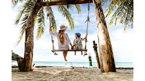Parent and child enjoying swing on beach