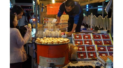 Couple eating street food Myeongdong, Seoul, KR 